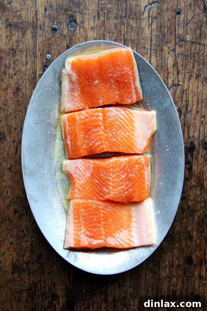 A sizzle platter showcasing beautifully arranged raw Arctic Char fillets, prepped for broiling.