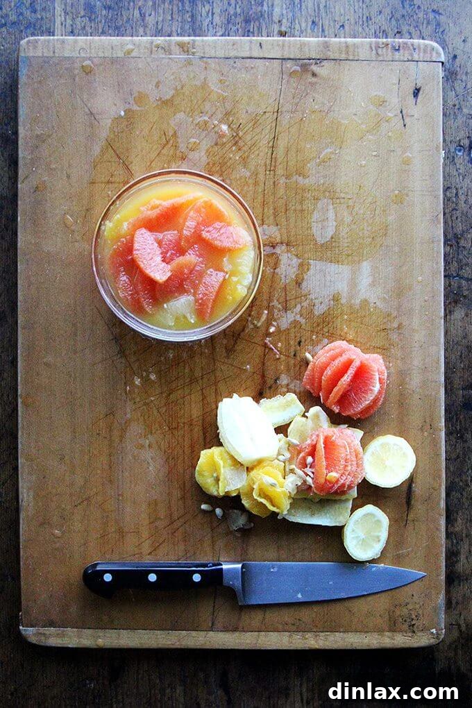Citrus rinds and pulp leftover after supreming, alongside a bowl of freshly prepared citrus sauce.