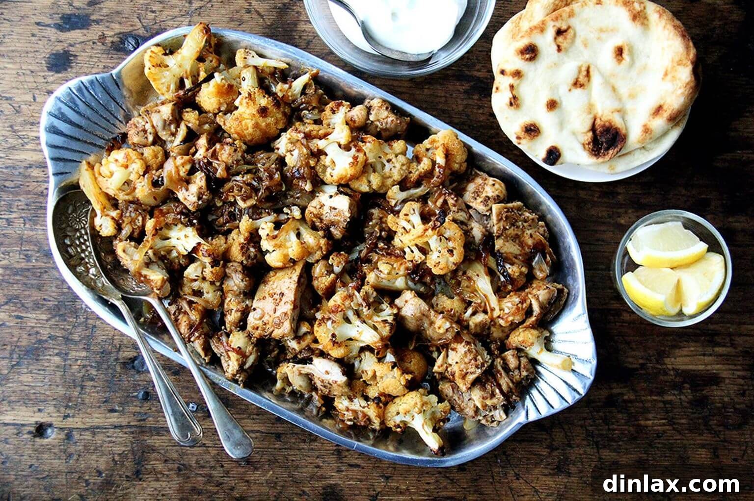 Close-up of a platter of sheet pan chicken and cauliflower shawarma, highlighting the crispy textures and vibrant colors.