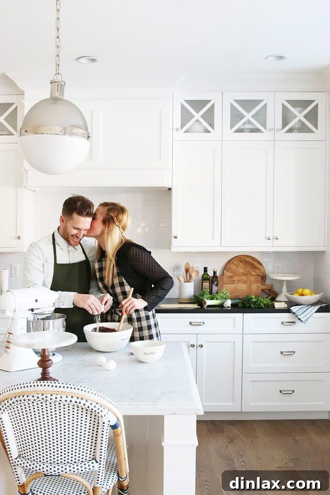 Shea and Syd McGee, the founders of Studio McGee, smiling warmly in a beautifully designed home setting, showcasing their approachable and cheerful aesthetic.