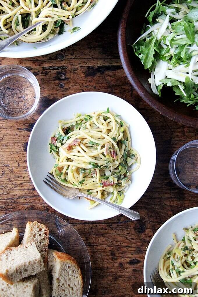 The finished bucatini carbonara, garnished with a generous amount of freshly grated Parmesan and black pepper, served in a rustic bowl.
