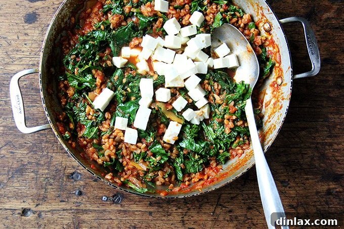 Mediterranean Farro Risotto with Kale and Feta 5 Overhead view of farro risotto with vibrant chopped kale and cubed feta cheese just added and gently folded in.
