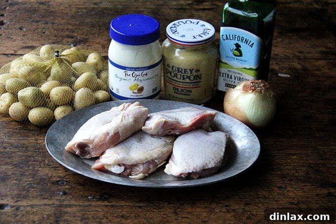 Sheet Pan Tarragon Chicken and Potatoes 3 The ingredients to make sheetpan roast chicken and potatoes, including chicken thighs, potatoes, onion, mayonnaise, mustard, olive oil, salt, pepper, and fresh tarragon.