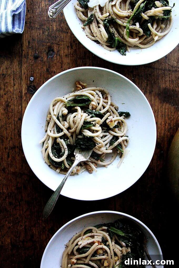 Freshly cooked pasta with vibrant spinach, crunchy walnuts, and a zesty lemon cream sauce, perfect for a spring meal.