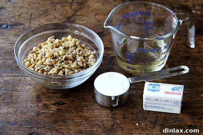 Prepared ingredients for pasta: toasted walnuts, butter, white wine, and crème fraîche, neatly arranged.