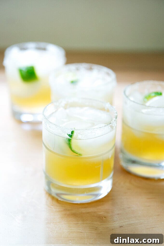 Classic margarita with tequila and lime, garnished with a lime wedge and a salted rim.