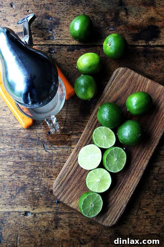 Overhead shot of a juicer with halved limes, ready to be squeezed for fresh lime juice.