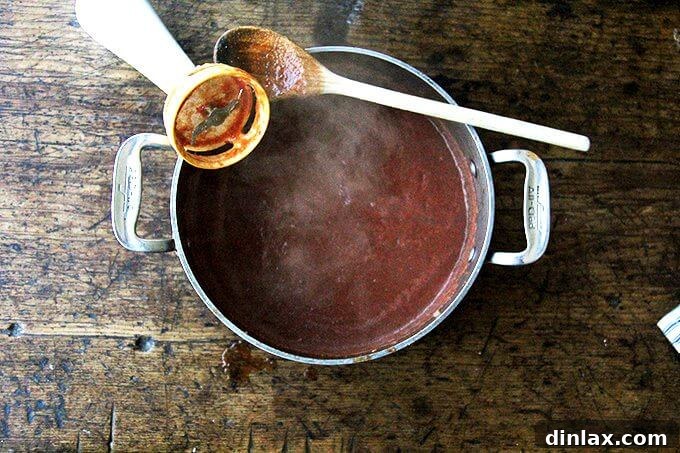 A hand blender puréeing the enchilada sauce in a pot.