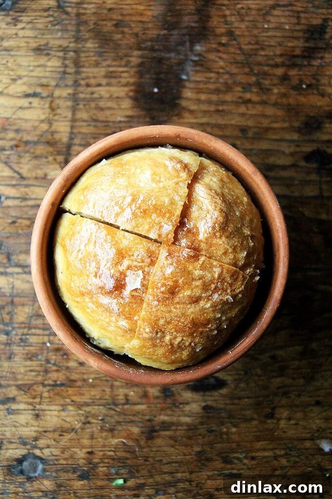 A warm flowerpot bread loaf, freshly baked, brushed with butter and generously sprinkled with coarse sea salt. // alexandracooks.com