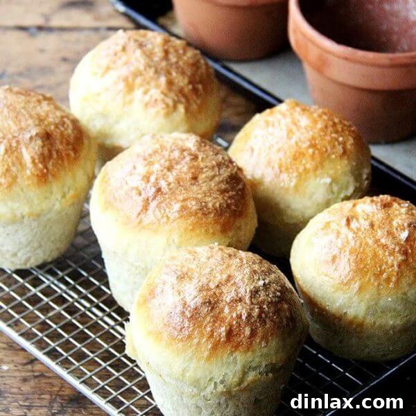 A perfectly golden flowerpot bread loaf, sliced to reveal its airy texture, brushed with butter and sprinkled with sea salt.