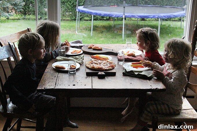 Mastering Skillet Pizza Perfection 17 Sideview of 4 kids eating skillet pizza and carrots.