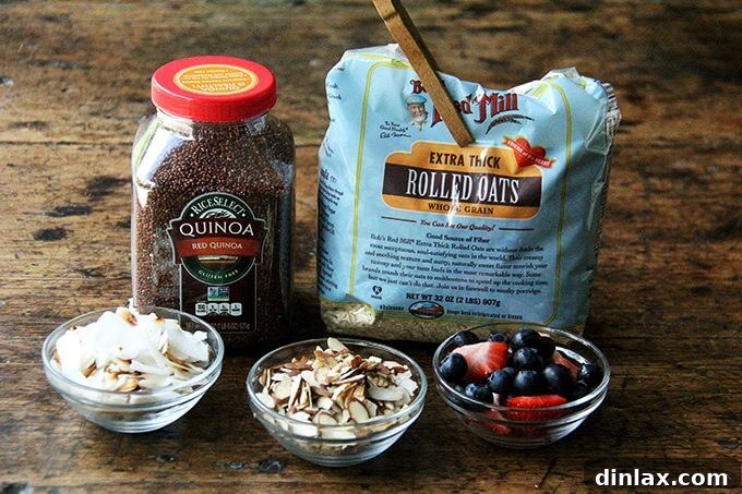 Fresh and Wholesome Ingredients for a Healthy Oat and Quinoa Porridge A vibrant selection of fresh, raw ingredients laid out for making Jean Adamson's Oat and Quinoa Porridge. The image features high-quality rolled oats, unrinsed quinoa, a carton of almond milk, whole cardamom pods, and a dried bay leaf, ready for preparation.