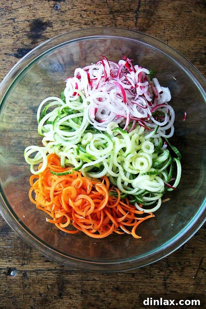 Nutty Sesame Soba Noodles with Tangy Pickled Vegetables 2 Spiralized carrots, cucumbers, and radishes prepped to become quick-pickled vegetables for an easy and refreshing soba noodle salad. These quickles add a fantastic tangy crunch to the dish. #soba #noodles #summer #quickles #almondbutter #vegan #dairyfree