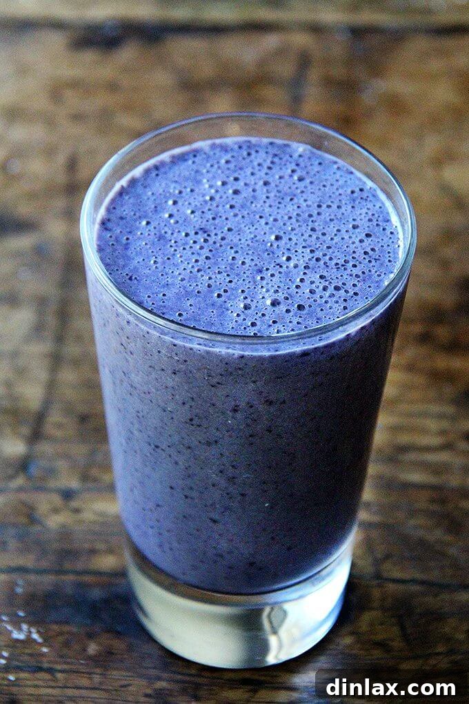 Blueberry Almond Vitality Smoothie 4 A tall, elegant glass brimming with a rich blueberry-almond smoothie, ready to be sipped.