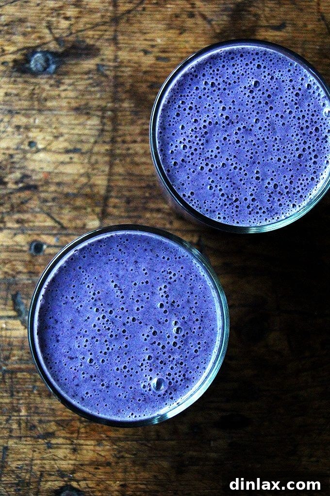 Blueberry Almond Vitality Smoothie 5 Two glasses of vibrant blueberry-almond smoothies, artfully presented, inviting you to share or savor a generous serving.
