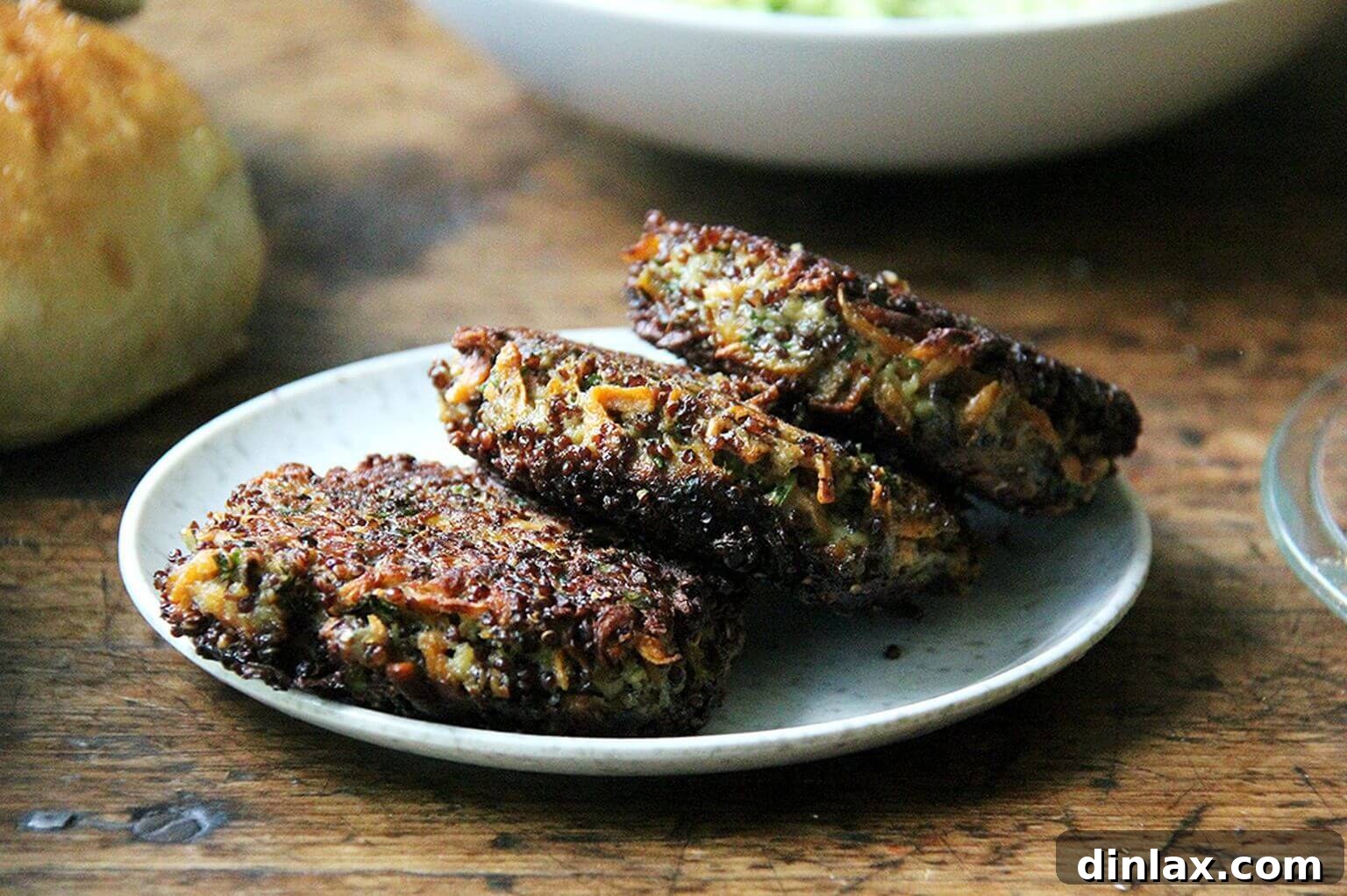 A tantalizing plate featuring three perfectly crispy, golden-brown mushroom and quinoa veggie burgers, showcasing their inviting texture.