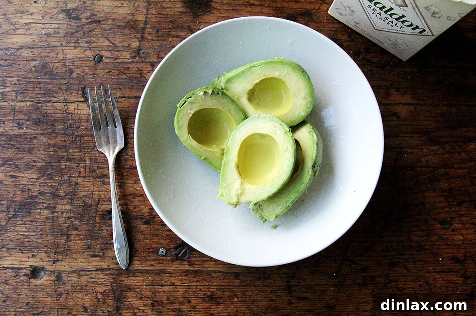 A simple bowl holding two ripe, green avocados, key for the creamy mashed avocado topping.
