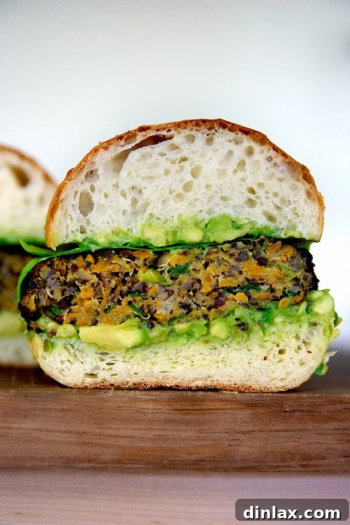 A perfectly halved sweet potato and quinoa veggie burger, revealing its vibrant interior and hearty texture, inviting a closer look.