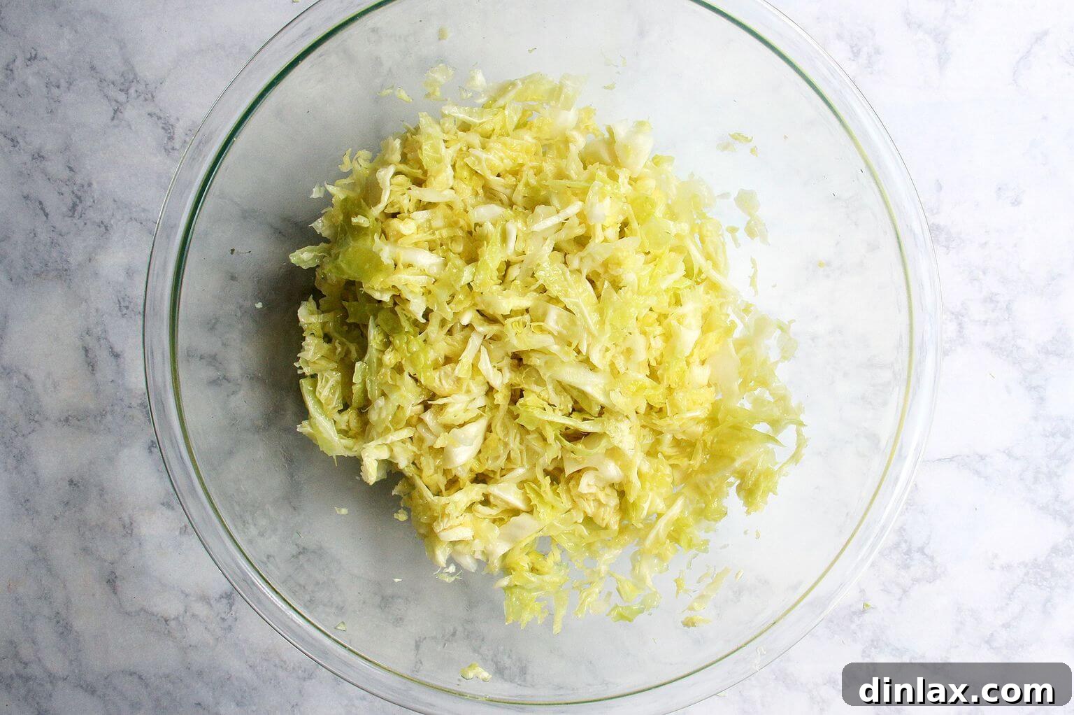 A bowl of massaged cabbage, visibly softened and vibrant in color.