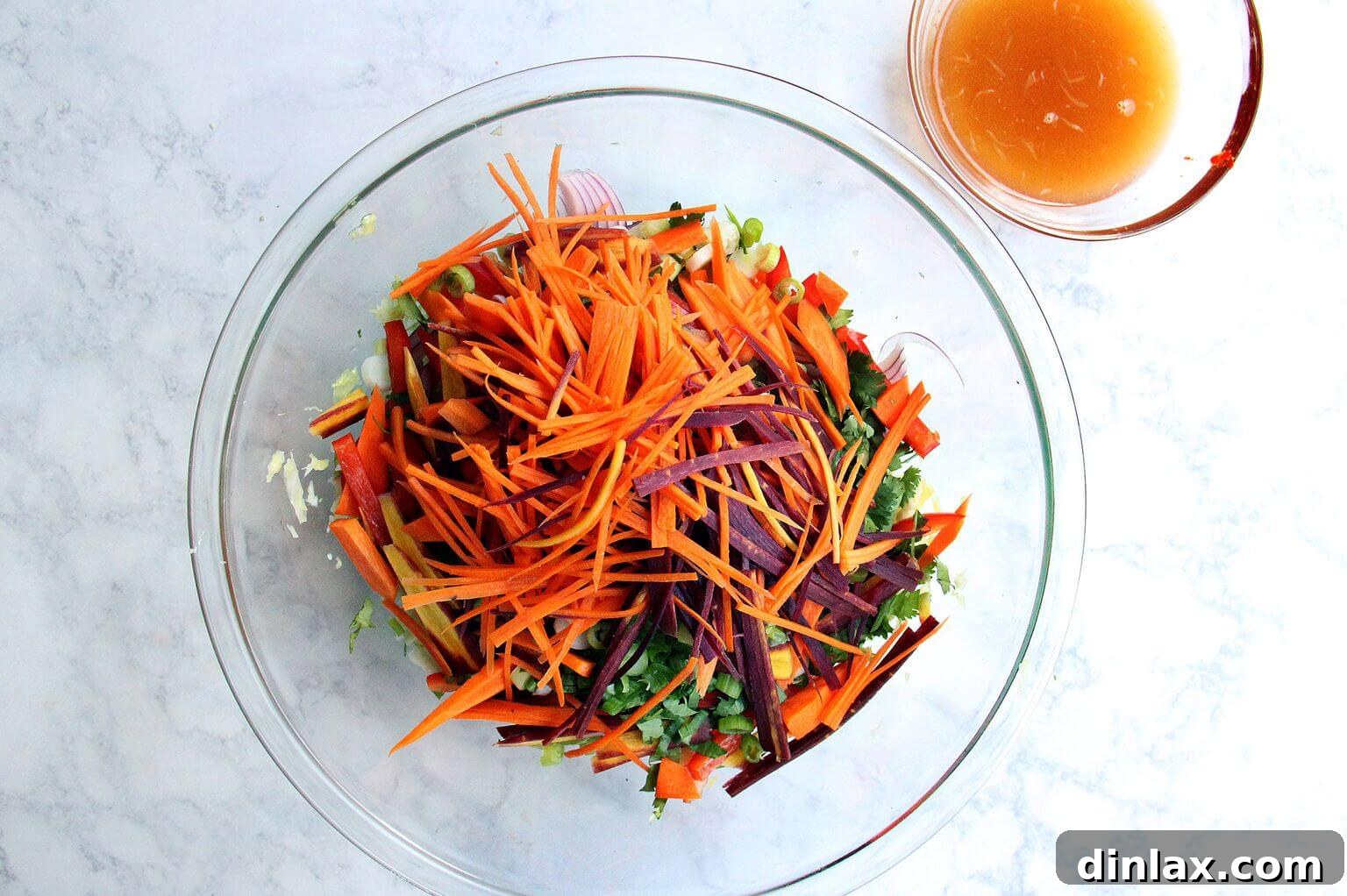 A bowl of julienned carrots, adding sweetness and crunch to the salad.