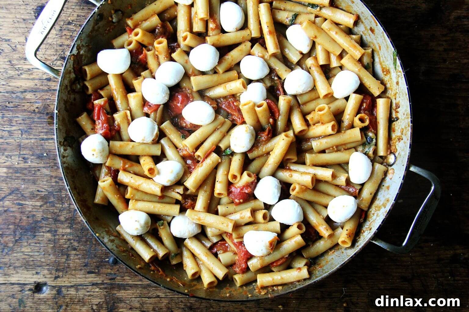 The large skillet of one-pan baked ziti now topped with an even layer of ciligiene mozzarella balls, ready for broiling.