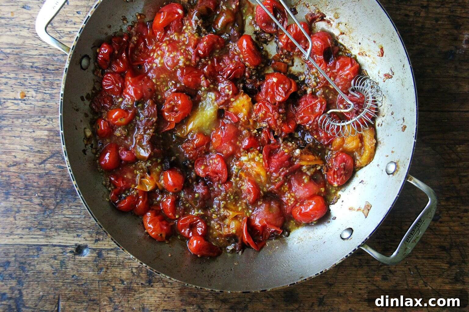 The skillet now holds mashed cherry tomatoes, transformed into a rustic, flavorful sauce, ready for the next step.