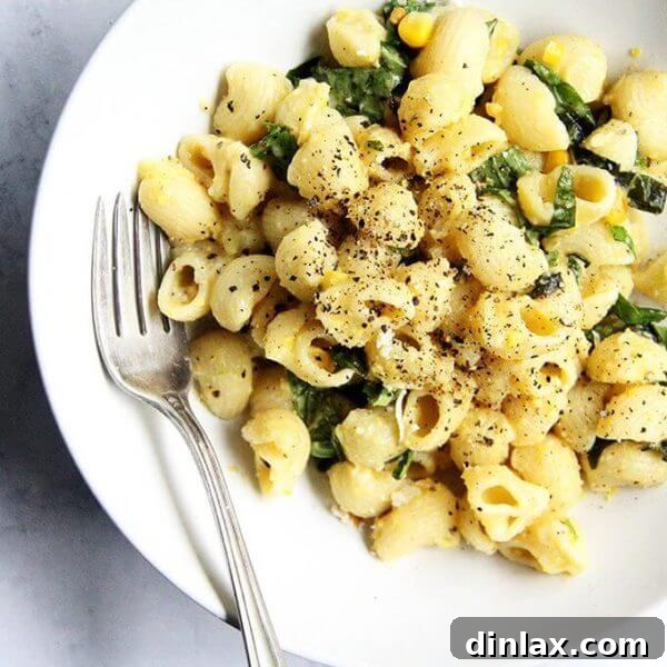 A bowl of creamy corn pasta, garnished with fresh basil.