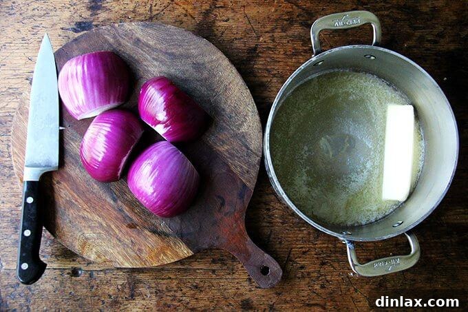 Marcella Hazan's Effortless Butter and Onion Tomato Sauce 4 A board of halved onions aside a pot with a stick of butter melting in it.