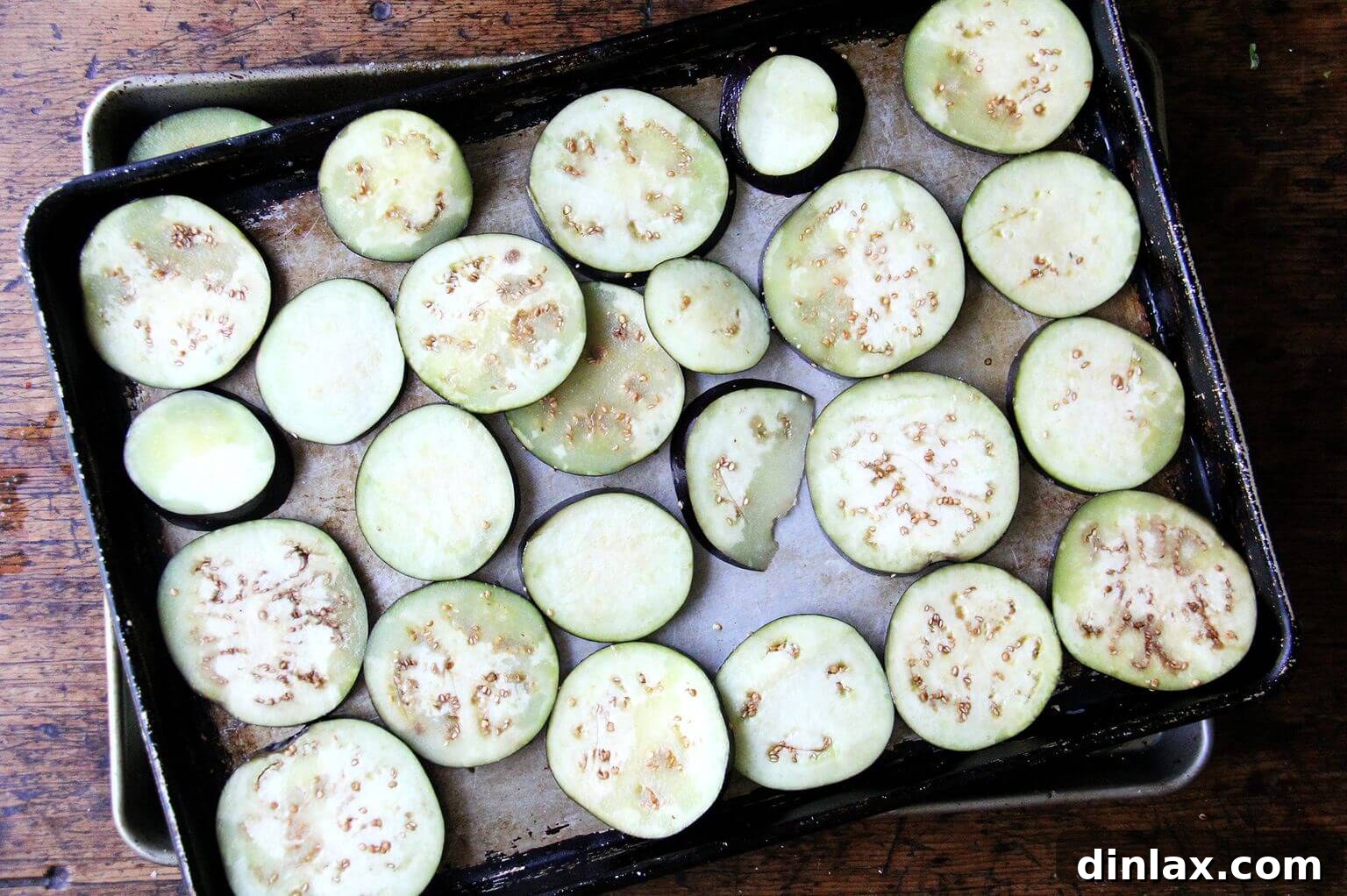 Thinly sliced eggplant rounds seasoned and ready for roasting.