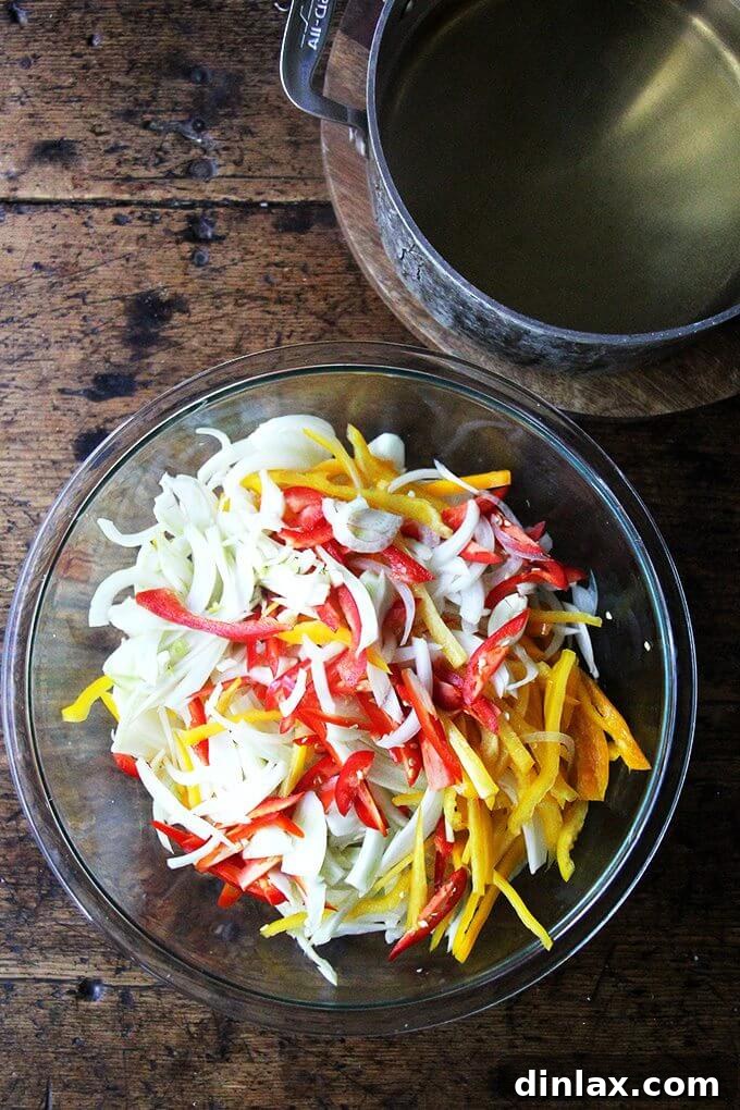 Hot pickling liquid being poured over a bowl of sliced vegetables.
