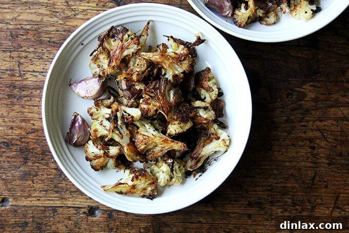 A pristine white bowl overflowing with beautifully roasted cauliflower florets, caramelized onions, and golden Parmesan, ready to be enjoyed.