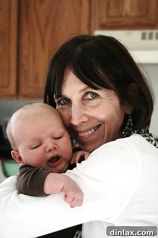 My mom and graham. A tender moment captured between a grandmother and her newest grandson, with the aroma of freshly baked apple cake likely filling the air.
