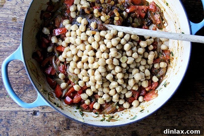 Sweet and Savory Chickpea Tagine with Tomato Jam and Roasted Delicata Squash 12 Cooked chickpeas and golden raisins added to the fragrant tomato and spice base in the Le Creuset braiser, ready for simmering.
