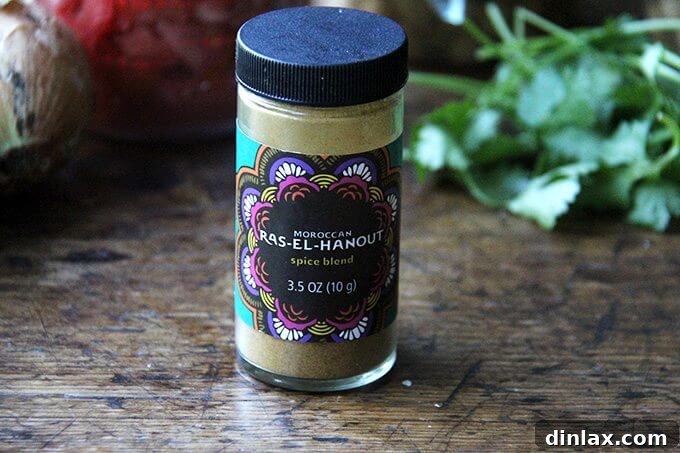 Sweet and Savory Chickpea Tagine with Tomato Jam and Roasted Delicata Squash 5 A small jar filled with the fragrant, golden-brown spice blend known as Ras el Hanout, ready to infuse the tagine with Moroccan flavors.