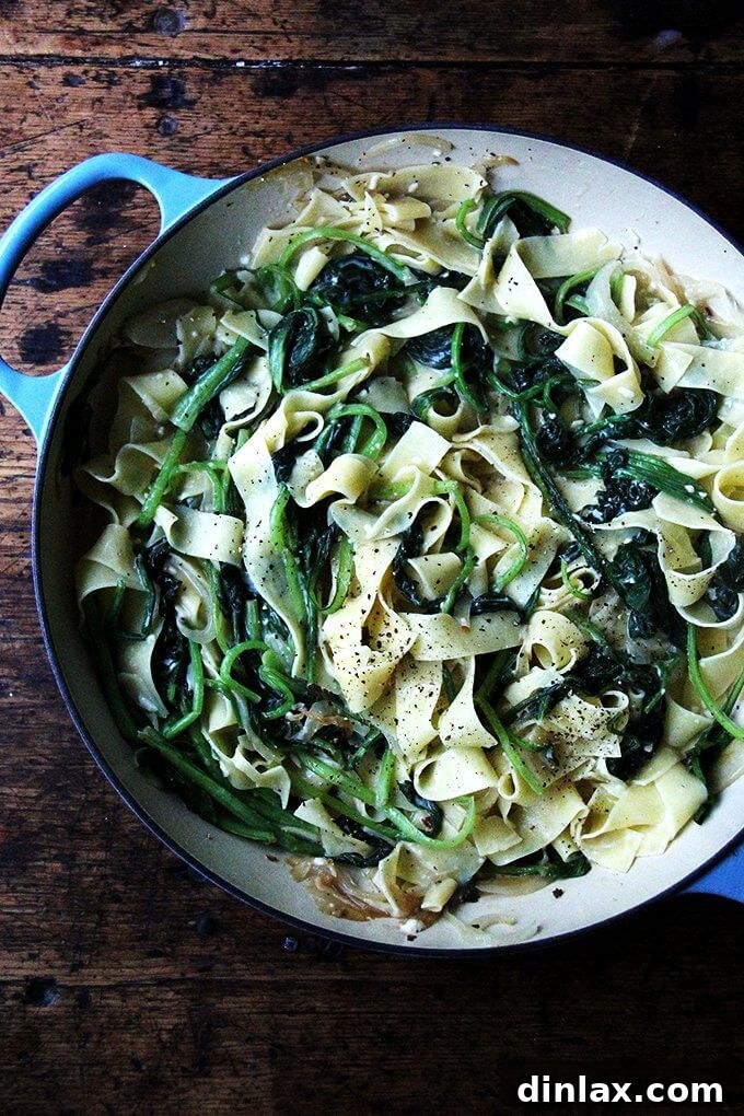 An overhead shot of a vibrant skillet filled with no-bacon carbonara, generously loaded with fresh, bright green vegetables and a creamy, rich sauce.
