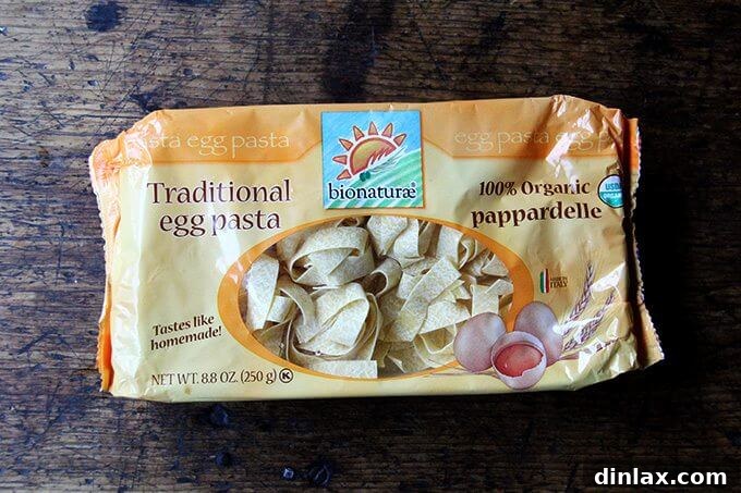 A package of pappardelle pasta, ready to be cooked, alongside other essential ingredients.