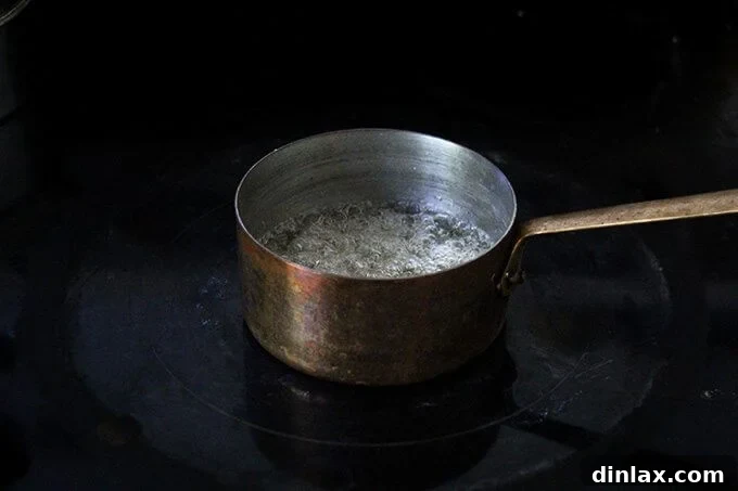 Sugar caramelizing in a small saucepan, turning a beautiful golden brown color.