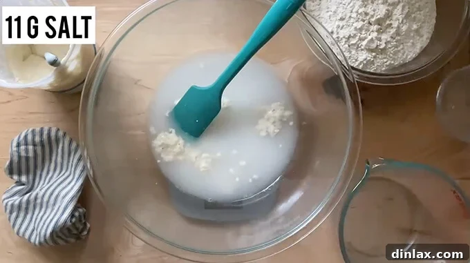 Mastering Sourdough: A Step-by-Step Homemade Journey 8 A bowl on a digital scale holding water, salt, and sourdough starter all mixed together.