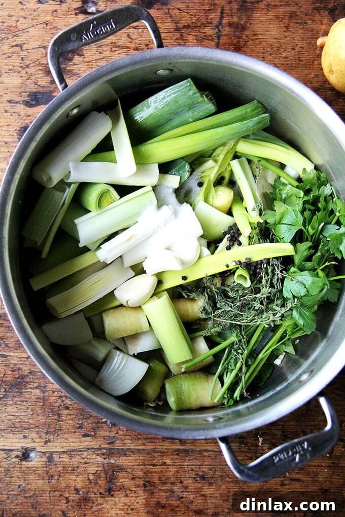 With soup season here, I thought it would be nice to give the vegetable stock recipe I love its own post. Here it is! It takes 45 minutes and will yield 2 quarts of flavorful broth to use in all of your favorite soups in the months ahead. // alexandracooks.com A large pot brimming with colorful vegetables, ready to be simmered into a rich, homemade vegetable stock. The ingredients promise a depth of flavor.