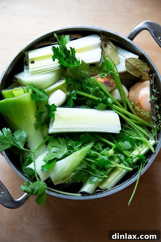 Pure Garden Stock 3 A large stockpot filled with a vibrant assortment of roughly chopped vegetables and fresh herbs, covered with water, ready for simmering.