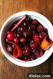 An overhead shot of a bowl of red wine cranberry sauce with cinnamon and orange zest.