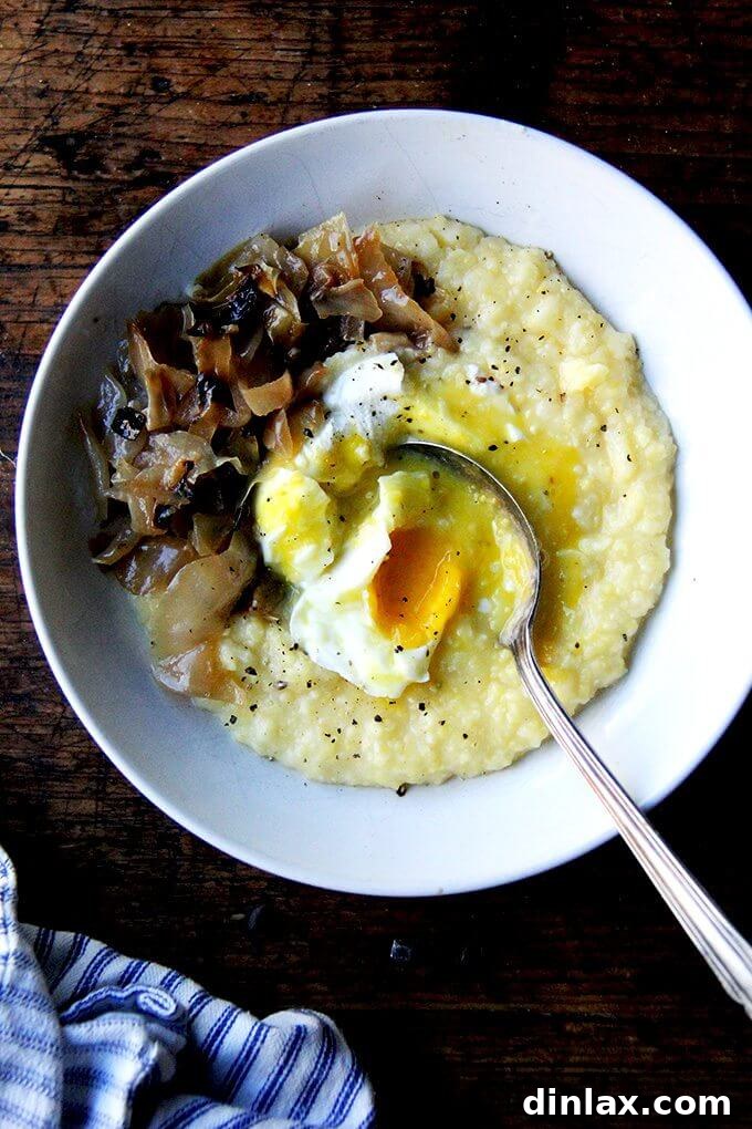 A beautifully presented bowl of creamy oven-roasted polenta, generously topped with a perfectly poached egg, inviting you to indulge in its comforting warmth.