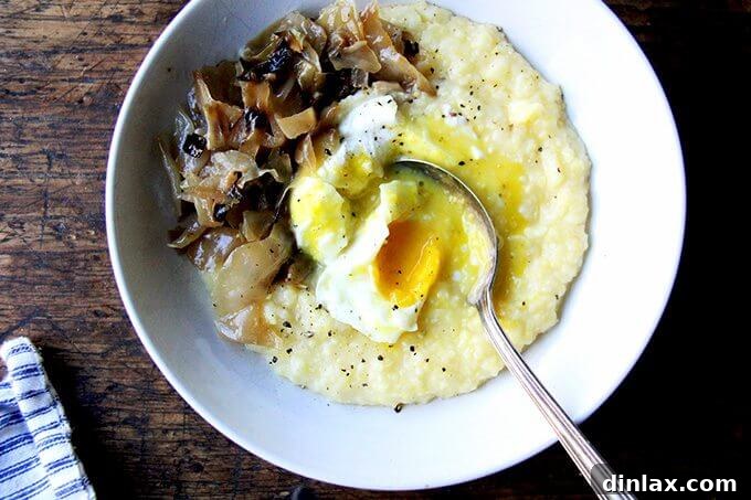 A close-up of a bowl of creamy polenta with a poached egg, the yolk perfectly broken to reveal its rich, golden liquid spilling over the polenta, inviting a taste.
