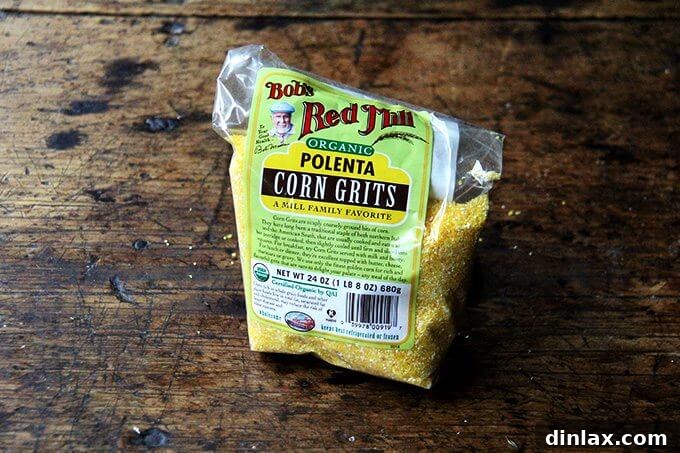 A close-up shot of a bag of medium-coarse, stone-ground polenta, highlighting the quality ingredient essential for a truly creamy and flavorful dish.