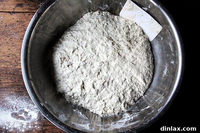 Deflating the risen dough with two forks, pulling it from the sides towards the center.