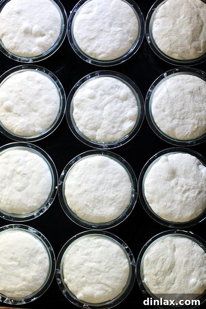 Two perfectly baked peasant bread loaves inverted onto a wire rack to cool.