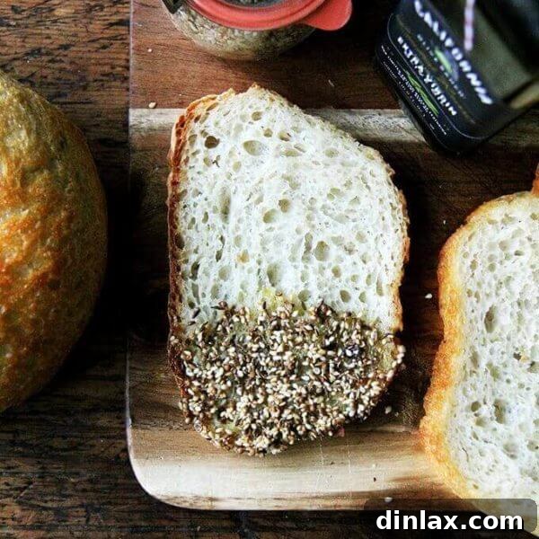 Crunchy Nut-Free Dukkah Blend 13 A bowl of homemade nut-free dukkah with a spoon, next to slices of bread for dipping.