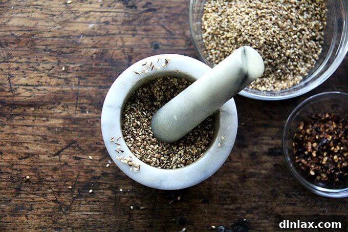 Crunchy Nut-Free Dukkah Blend 5 Toasted cumin, coriander, and sesame seeds in a mortar and pestle, ready for crushing.