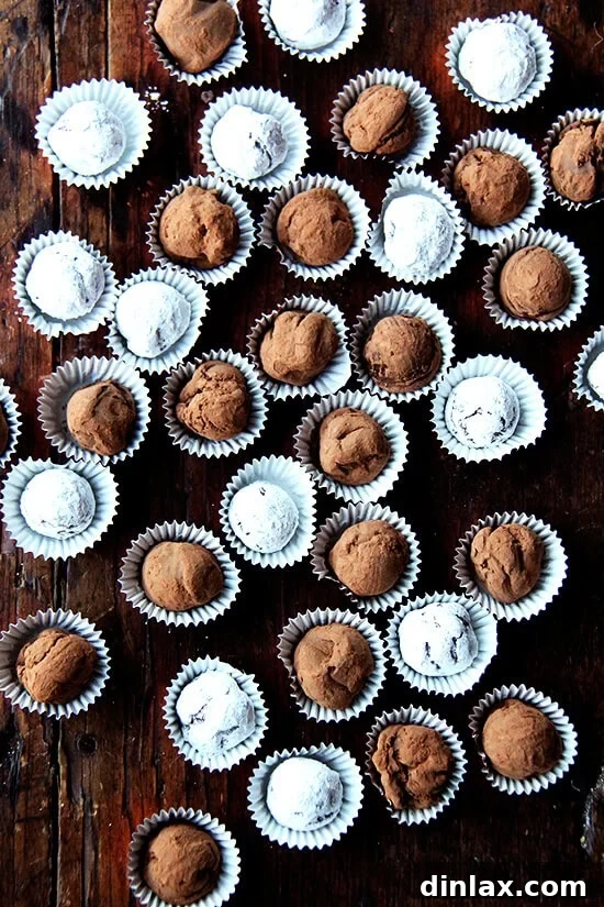 Luxurious Grand Marnier chocolate truffles, delicately dusted with cocoa powder, arranged elegantly on a wooden board.