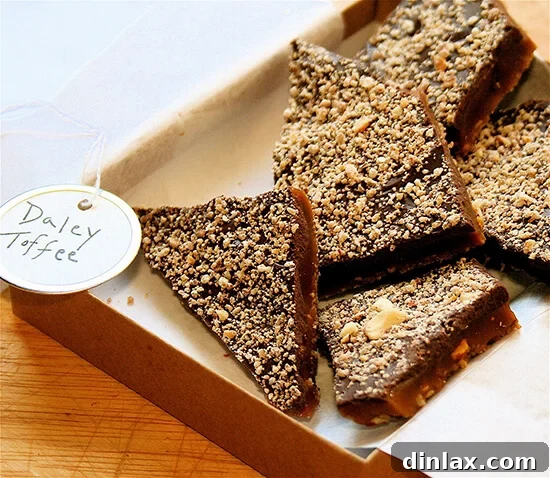 A delightful box filled with glistening shards of homemade Daley family toffee, generously sprinkled with chopped nuts.